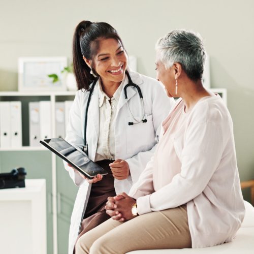 Mature patient, doctor and tablet for healthcare, support or conversation with checkup appointment in office. Female person, medical professional and diagnosis talk for senior woman at clinic.